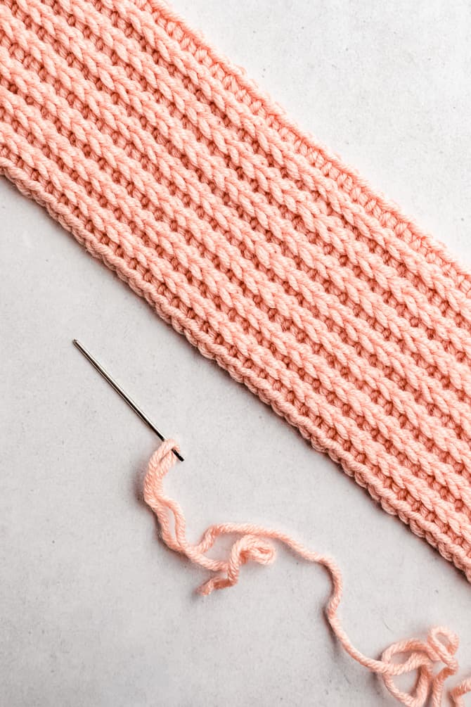 needle with yarn to seam the ear warmer