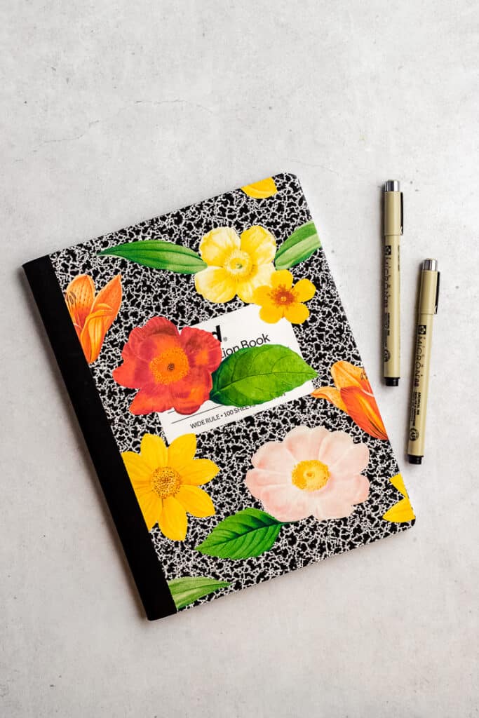 personalizado de flores adesivos em um caderno de composição com canetas