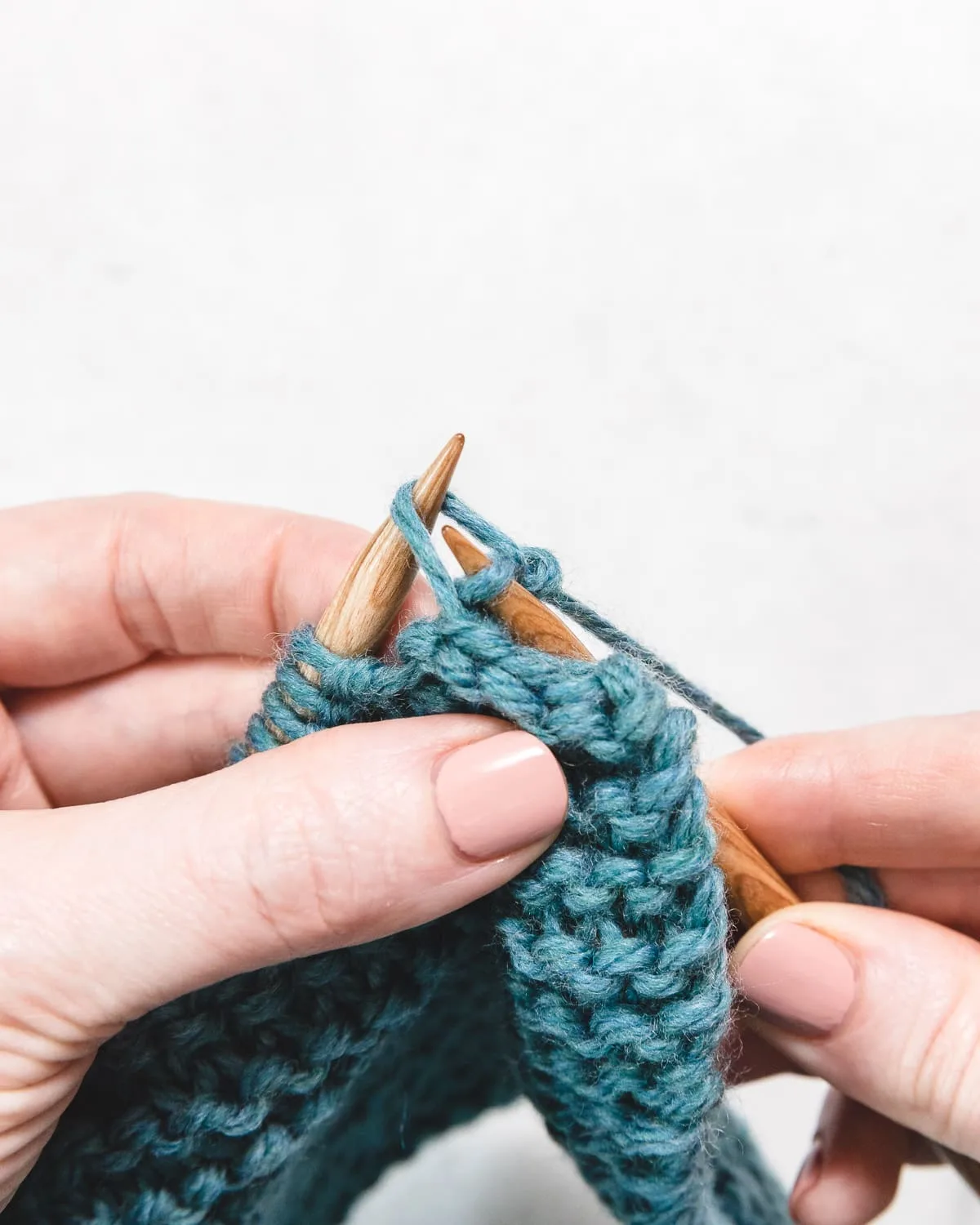 a step in casting off, passing the first stitch over the second stitch and off the needle