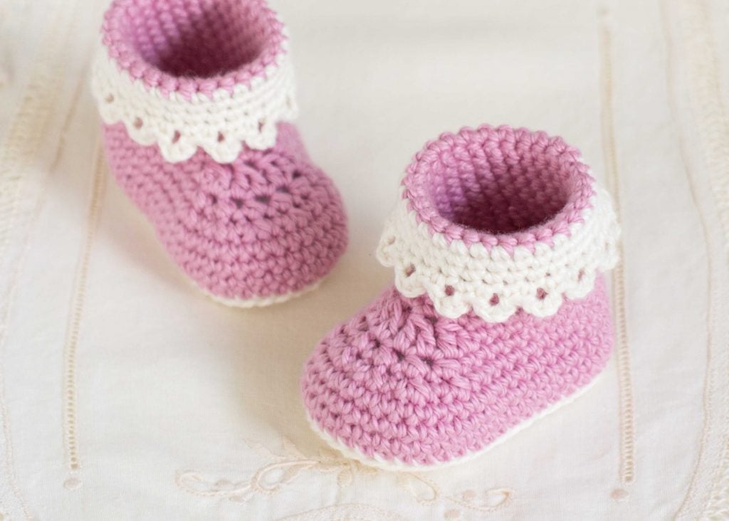 Pair of soft crochet baby booties in pastel yarn with ribbon ties
